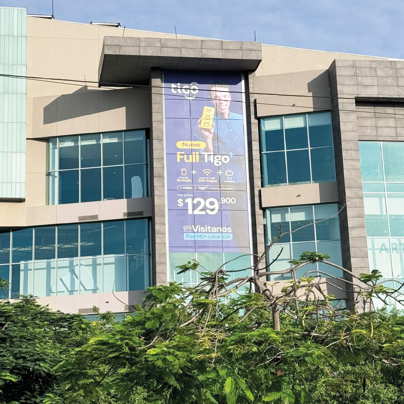 Gigantografía en vinilo blanco impresión con tintas ecosolventes sobre vinilo blanco laminado mate, instalado en  fachada de vidrio de centro comercial.